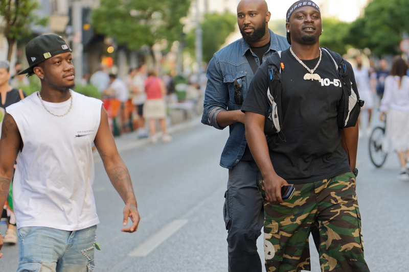16 - Three young African men casually walking down a city street in Bucharest
